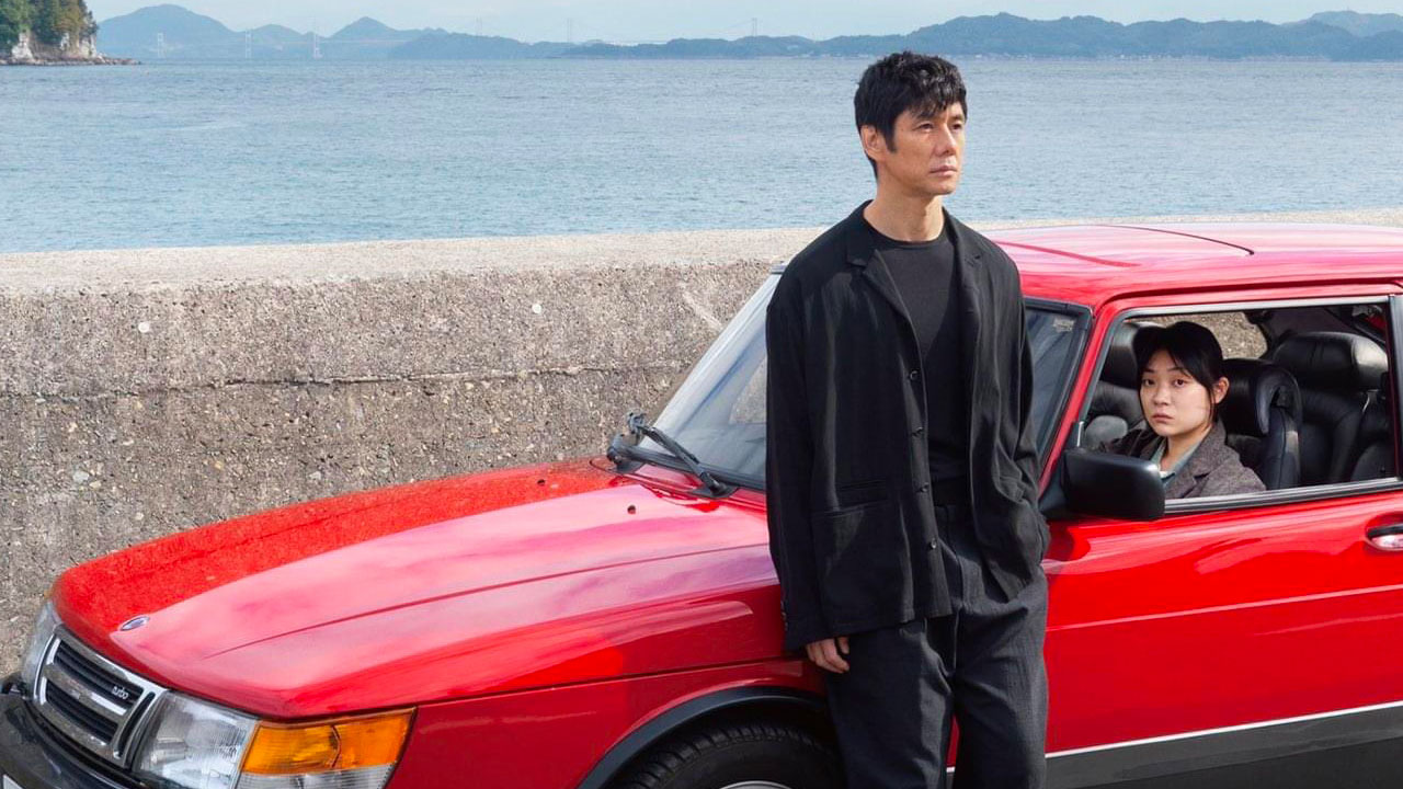 Yusuke (Hidetoshi Nishijima) stands beside his car, with Misaki Watari (Toko Miura) his driver sitting inside